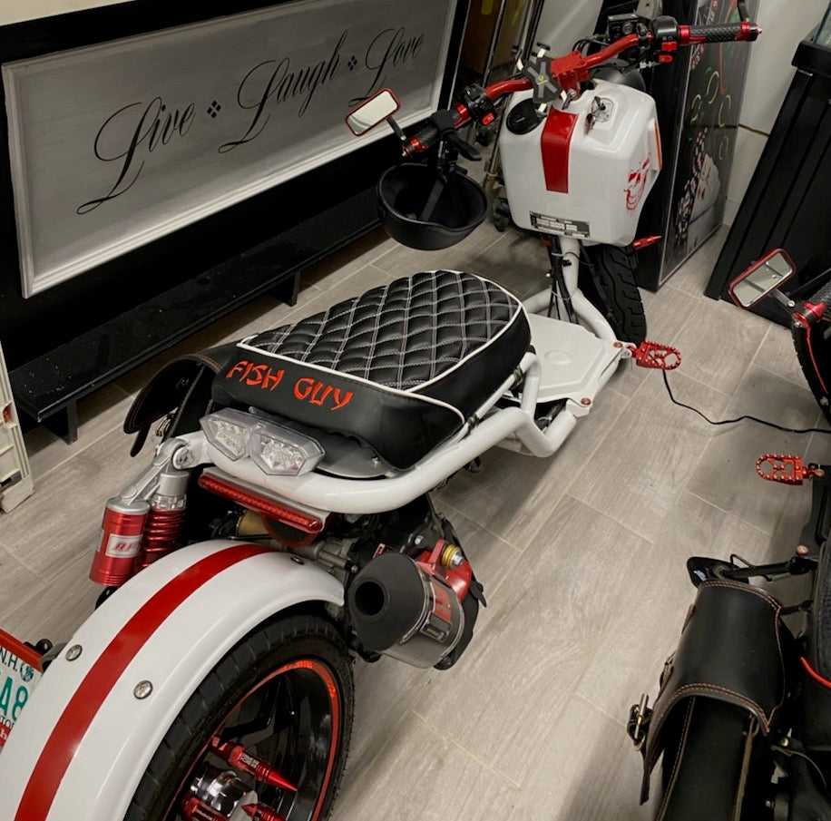 Customer photo of a white and red Maddog scooter with FISH GUY embroidery on the black diamond seat cover, handmade by Cheeky Seats