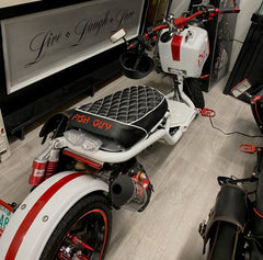 Customer photo of a white and red Maddog scooter with FISH GUY embroidery on the black diamond seat cover, handmade by Cheeky Seats
