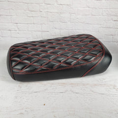 Side view of the satin black diamond seat cover with red stitching, showing the glossy sheen and smooth black side panels, handmade by Cheeky Seats