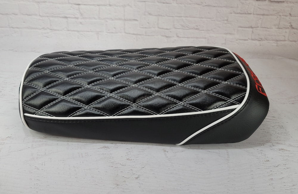 Black diamond seat cover with white piping and white contrast stitching, red embroidery on the rear panel, handmade by Cheeky Seats
