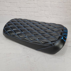 Satin black diamond seat cover with blue stitching, glossy sheen, and blue Cheeky Seats embroidery on the rear panel